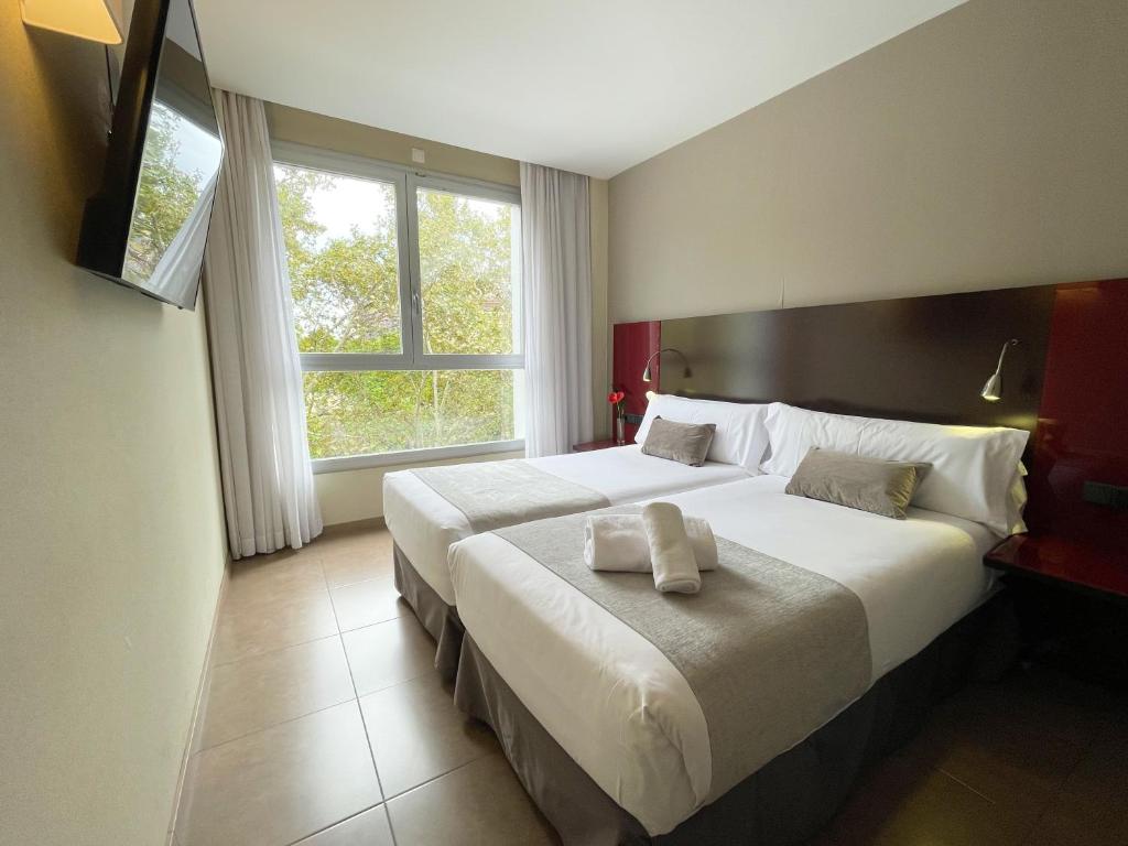 a hotel room with two beds and a window at SM Hotel Teatre Auditori in Barcelona