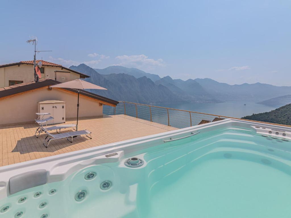 a swimming pool on a deck with a view of the water at EnjoyIseoLake - Blooming Lakefront in Fonteno