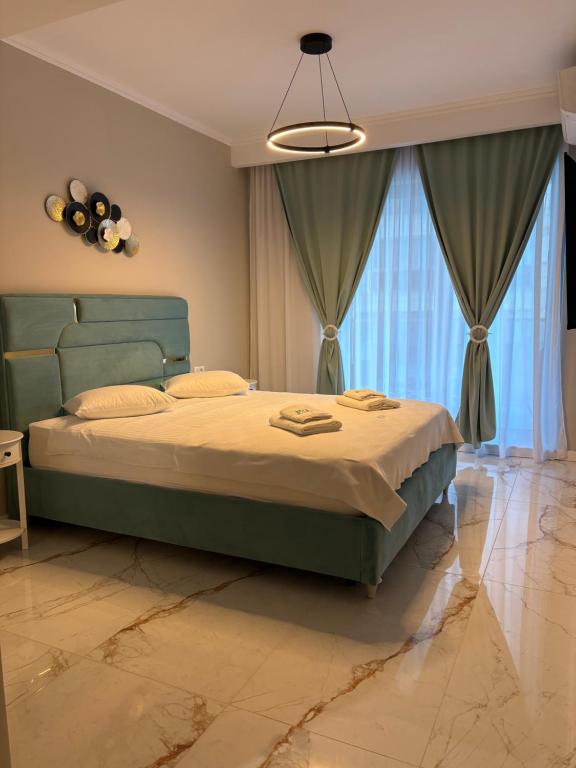 a bedroom with a large bed and a chandelier at F&L Relax Mamaia Nord -Apartament cu parcare gratuită in Mamaia Sat/Năvodari