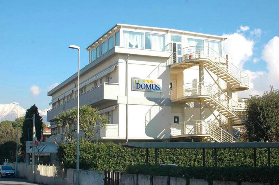 a white building with a donuts sign on it at Hotel Domus in Marina di Massa