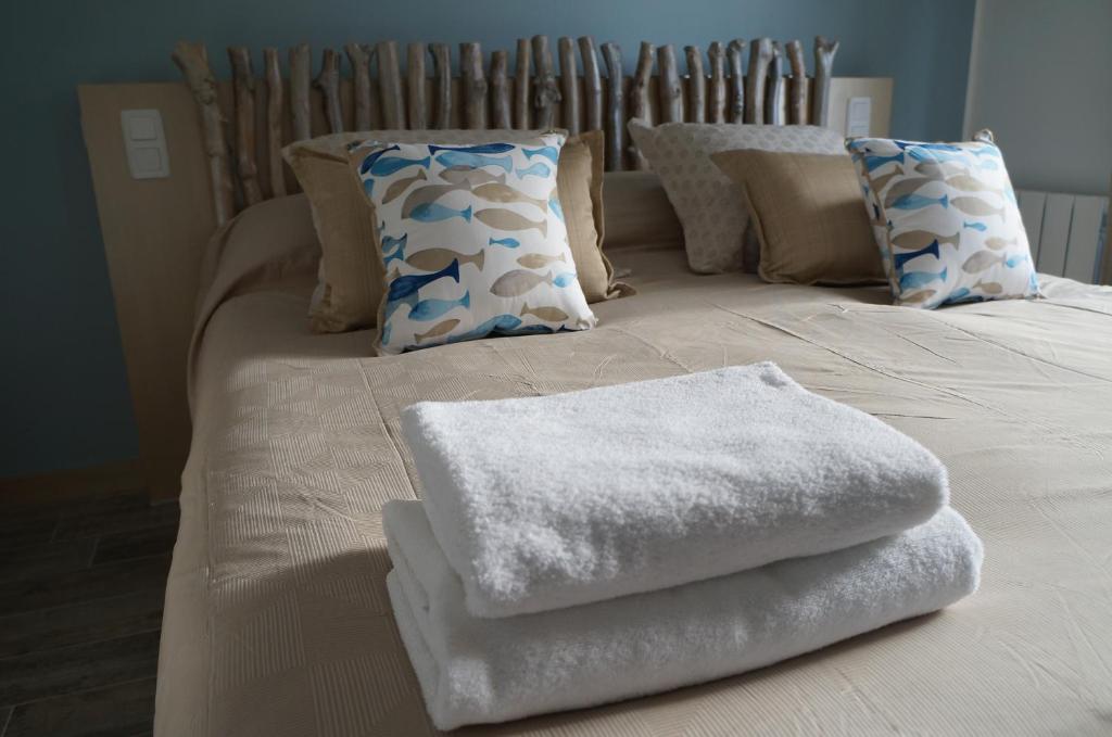 a bed with white towels on top of it at Vacation Home - Maison de vacances in Saint-Xandre