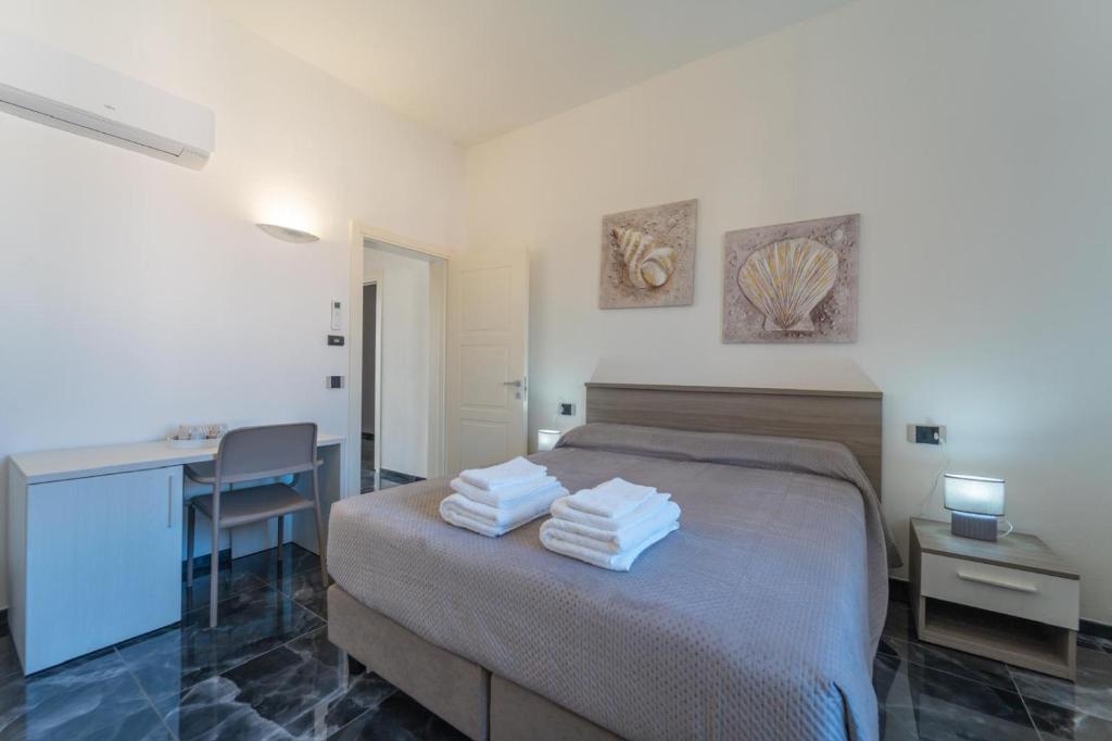 a bedroom with a bed and a desk with towels on it at dream house in Olbia
