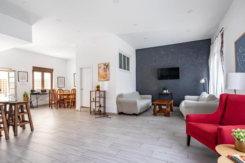 a living room with a red couch and chairs at Little Yellow House in Gijón