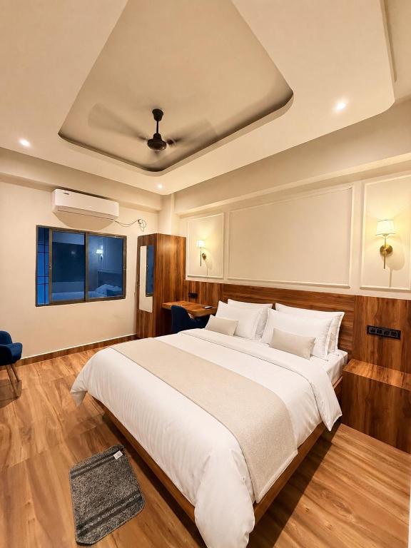 a bedroom with a large white bed and a window at Rishaan Regency in Silchar