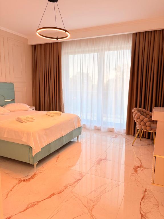 a bedroom with a bed and a large window at F&Lrelax-Apartamente de închiriat aproape de plajă in Mamaia Sat/Năvodari