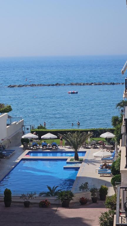 a swimming pool with a view of the ocean at Beach Front View Apartment Sea Pool & Prime Location in Limassol