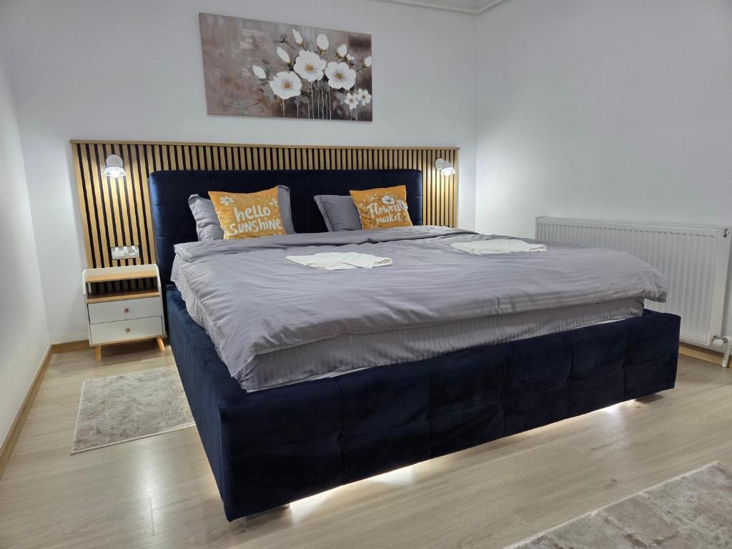 a bedroom with a large bed with a blue headboard at Luna Studio in Hunedoara