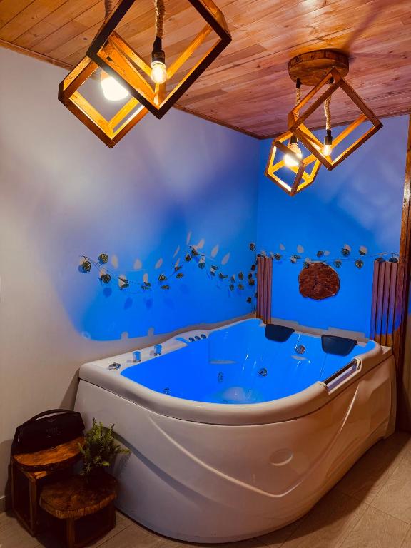 a large tub in a room with a blue wall at Lago de Tota GALAMPLAY lodge in Tota