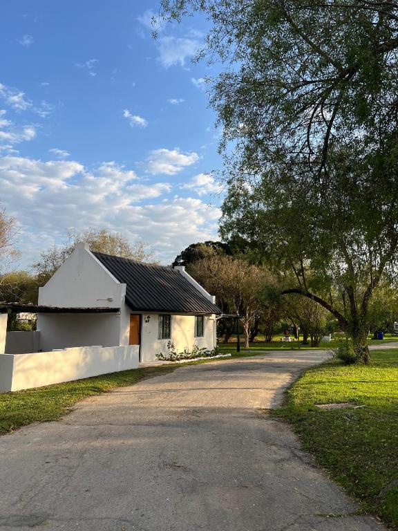 a road leading to a white house with a driveway at Kliprivier Park Tulbagh in Tulbagh