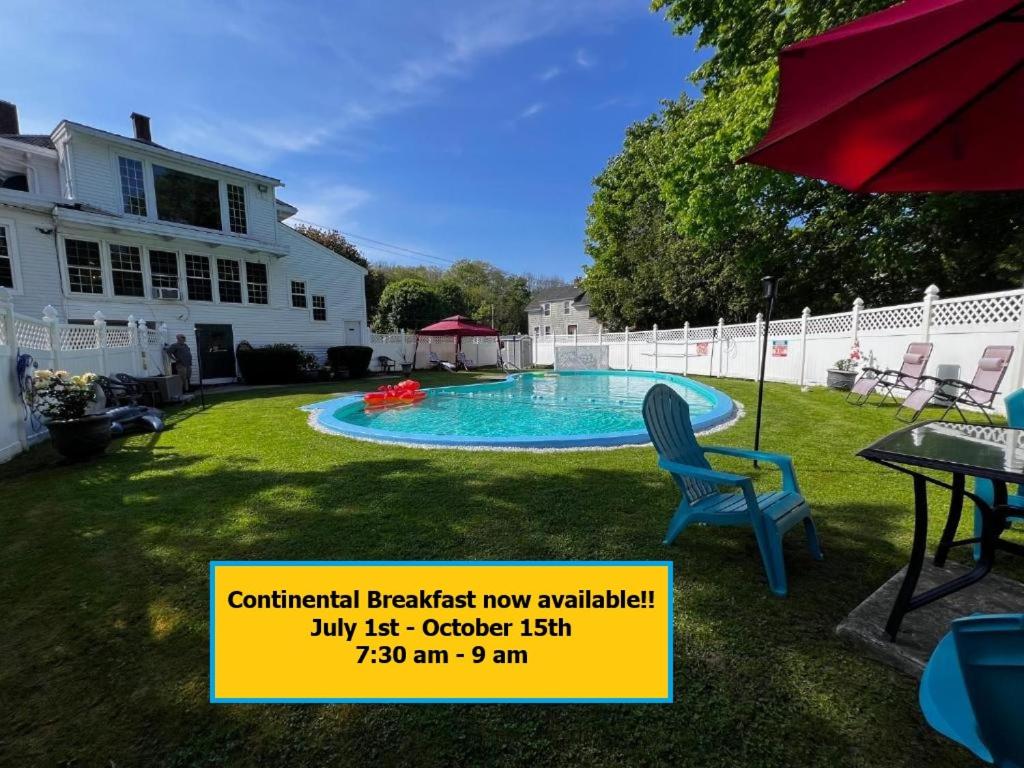 a sign for a backyard pool with a chair and a table at Claddagh Motel & Suites in Rockport