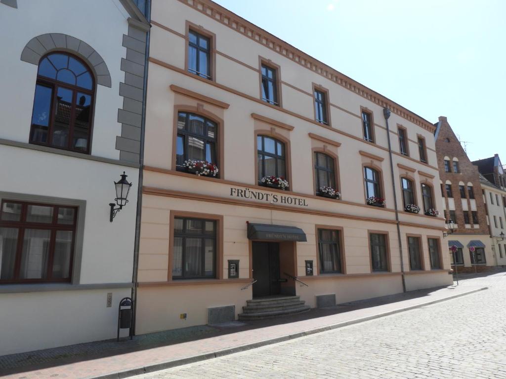 a building with a sign on the front of it at Fründts Hotel in Wismar