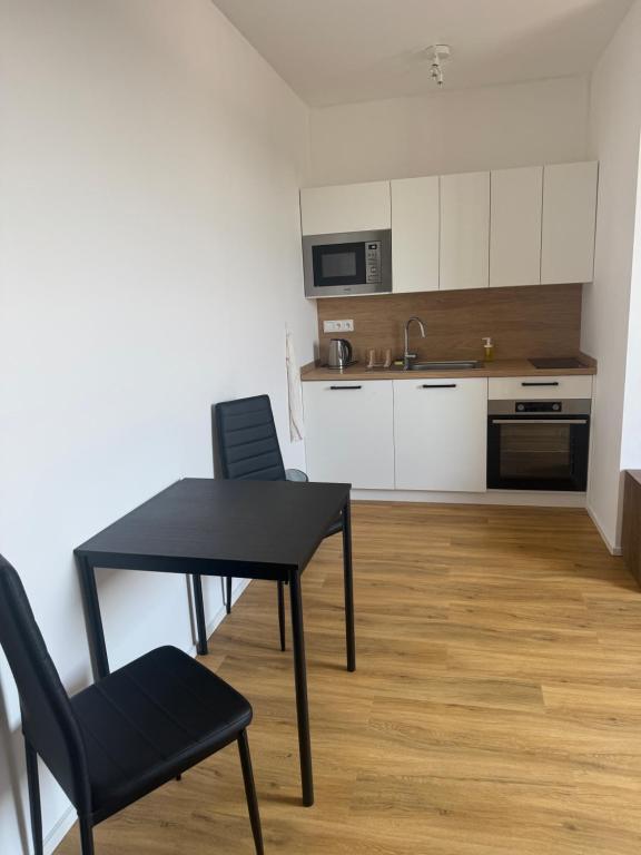 a kitchen with a black table and chairs in a room at StayCentralcz- Studio in Opava