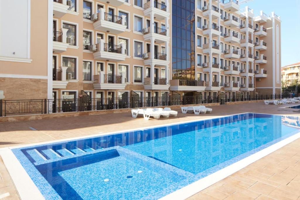 a swimming pool in front of a building at Polarstar Beach Resort - Premium Apartments in Sveti Vlas