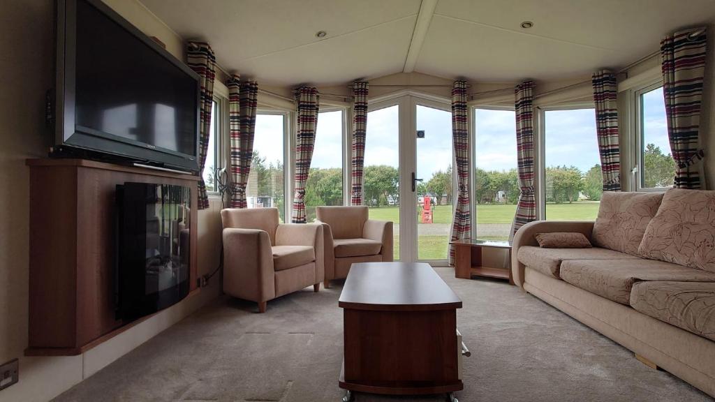 a living room with couches and a flat screen tv at Sandpiper Aspen 9 in Peterhead