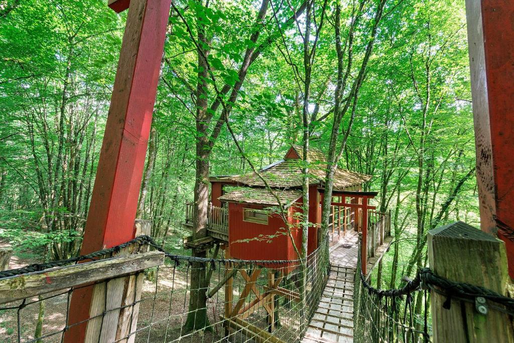 a suspension bridge in the middle of a forest at La Cabane Zen in Angoisse
