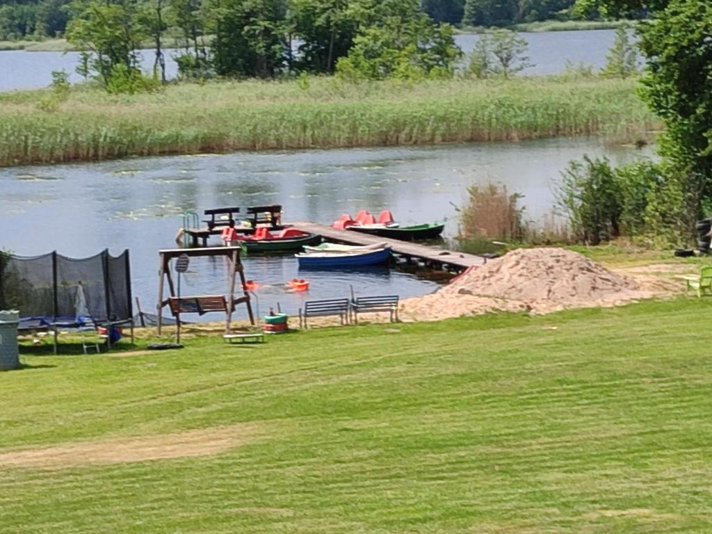 two boats are docked at a dock on a river at DOMEK NAD JEZIOREM in Żywki