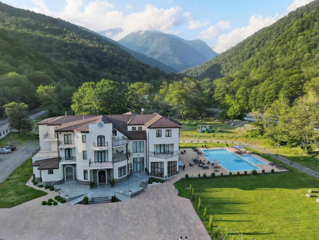 an aerial view of a house with a swimming pool and mountains at Sviana Resort in Telavi