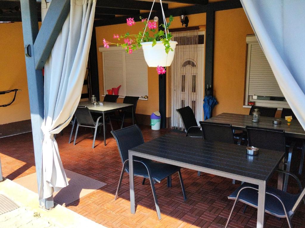 a dining room with tables and chairs and a hanging plant at Villa La Vita in Hévíz