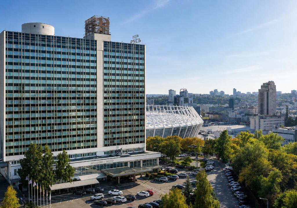 ein großes Gebäude mit auf einem Parkplatz abgestellten Autos in der Unterkunft Premier Hotel Rus in Kiew