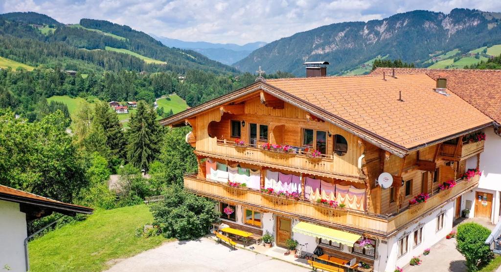 a large wooden house with flowers on the balcony at Hotel Biobauernhof Hinteraltensberg Wildschönau in Auffach