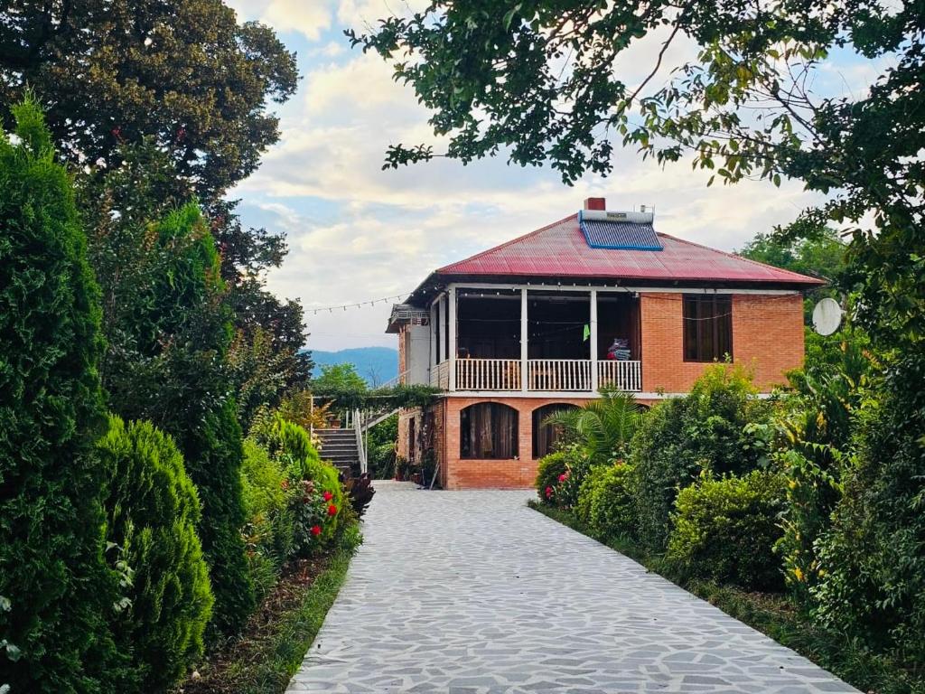 a house with a walkway leading to a building at Guesthouse Kamelia in Martvili