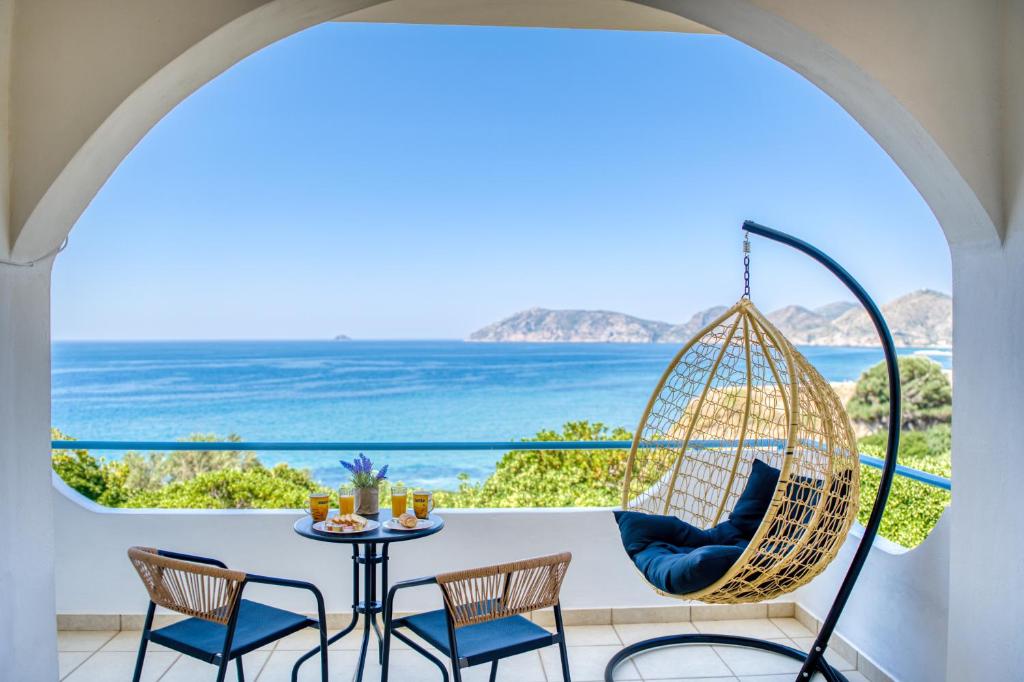 a porch with a swing and a table and chairs at Viri Blue in Ágios Ioánnis
