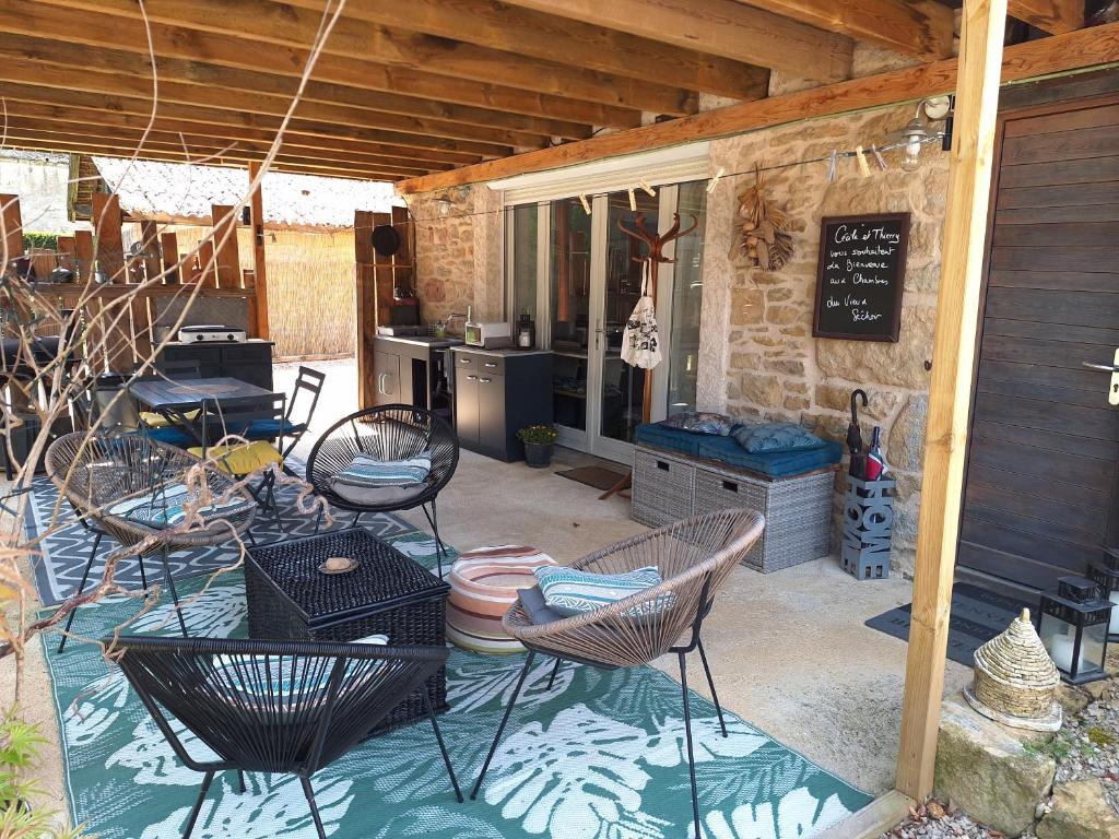 a patio with chairs and a table and a kitchen at Au Vieux Séchoir in Prudhomat