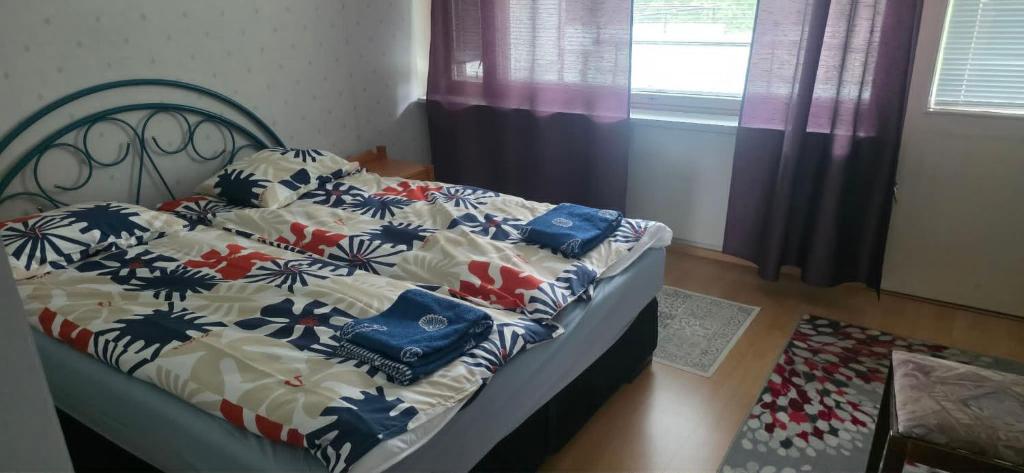 a bedroom with a bed with a floral comforter at Pankkikallio 16 in Sorsakoski