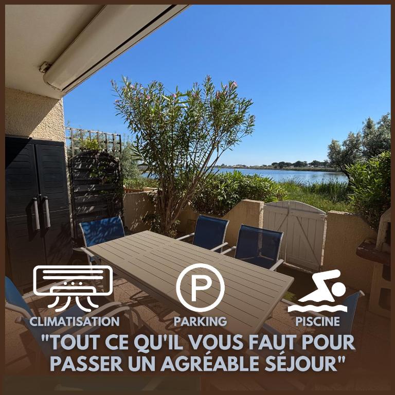 a patio with a table and chairs and a lake at La mer en liberté in Gruissan