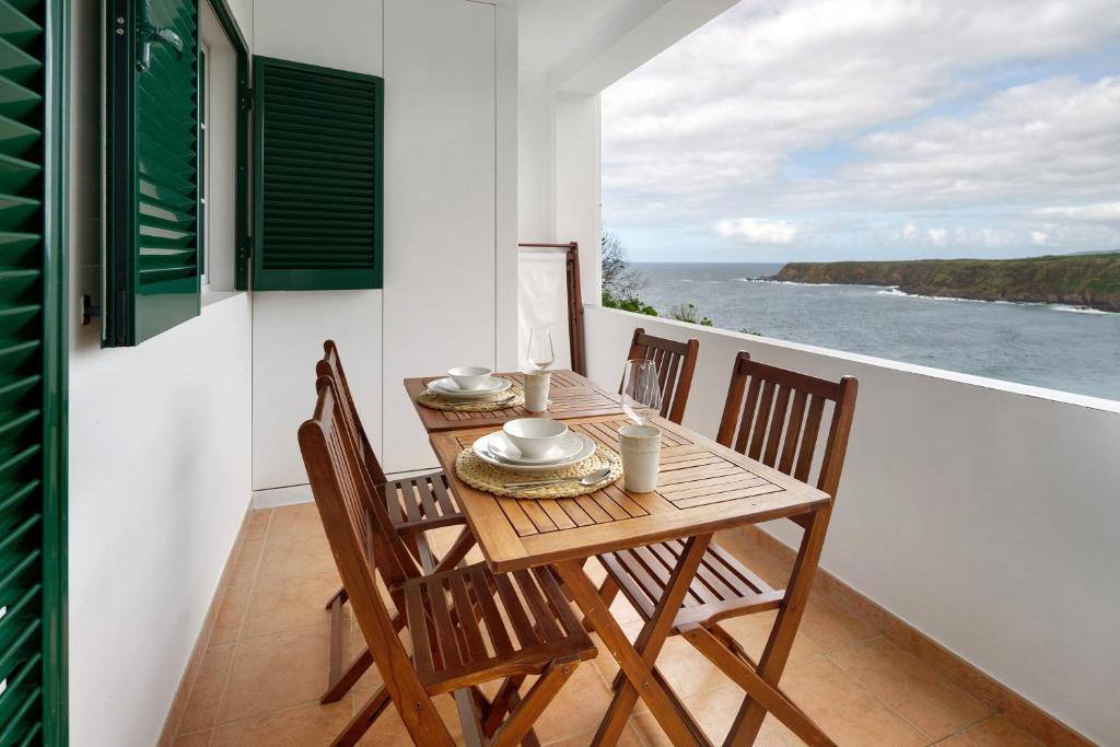 a dining room with a table and chairs and the ocean at Beach House - Mountain And Ocean in Porto Formoso