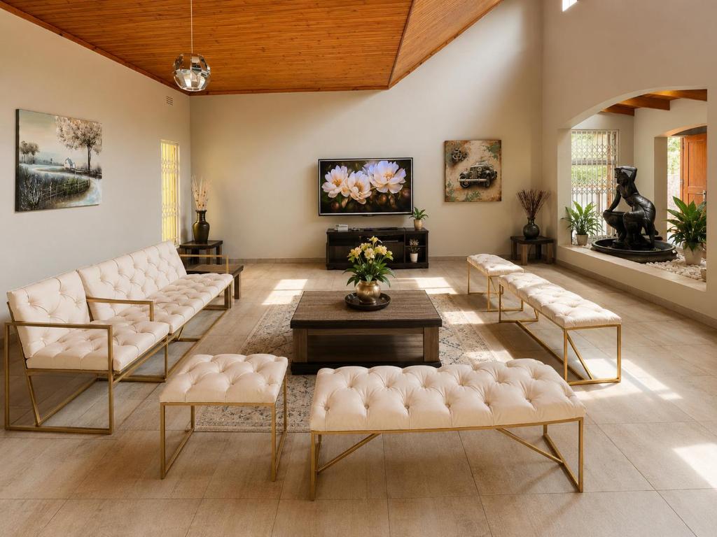 a living room with white couches and a tv at Hendrinas Guesthouse in Hendrina