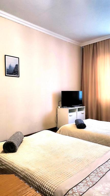 a hotel room with two beds and a flat screen tv at Водопійна 19 CityRooms in Bila Tserkva