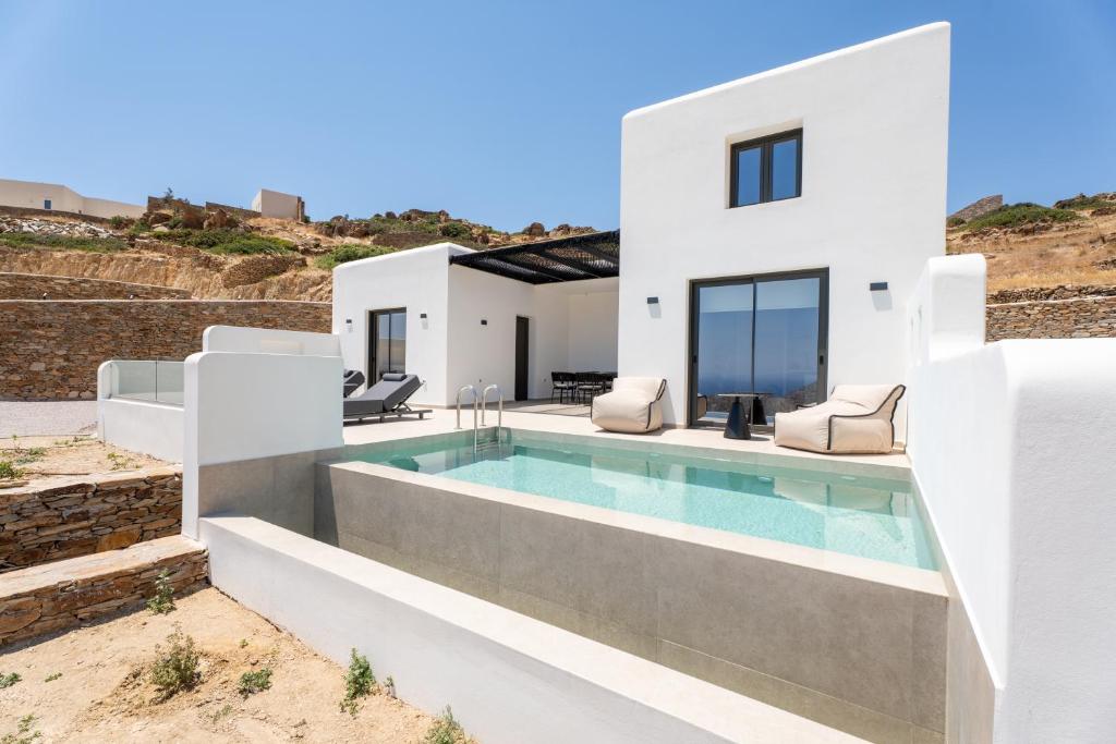 a white villa with a swimming pool at Serenity Villas in Ios Chora