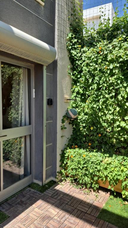 a door to a house with a green hedge at Luna BaNeguev in Yeroẖam