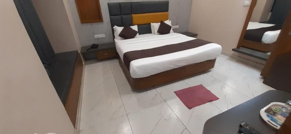 a bedroom with a bed and a mirror at Hotel Purushottam in Dwarka