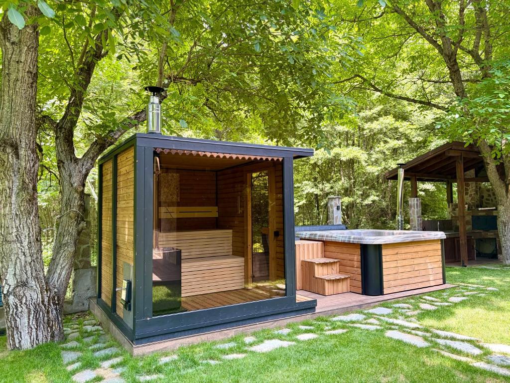 a tiny house in a garden with a tree at Къща за гости Амая - Сандански in Sandanski