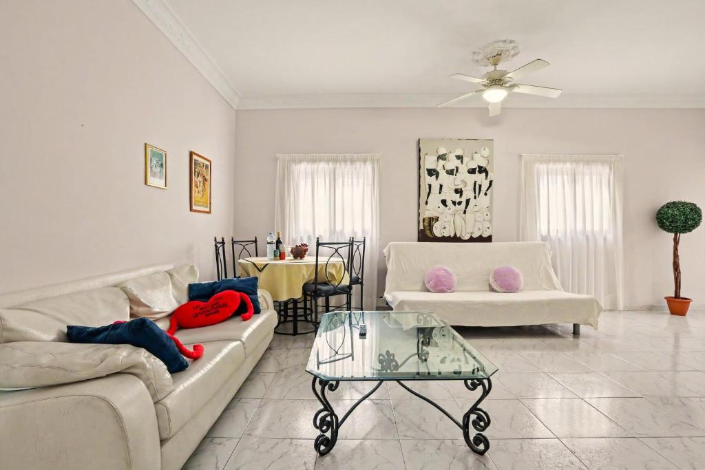 a living room with two couches and a glass table at Beach 2-bedroom in Los Cristianos in Los Cristianos