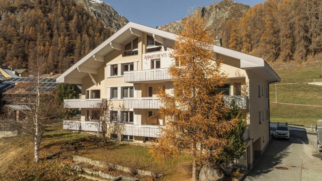 an apartment building with a mountain in the background at Atlantis Apartments by MEIN SAMNAUN - MOUNTAIN HOMES in Samnaun