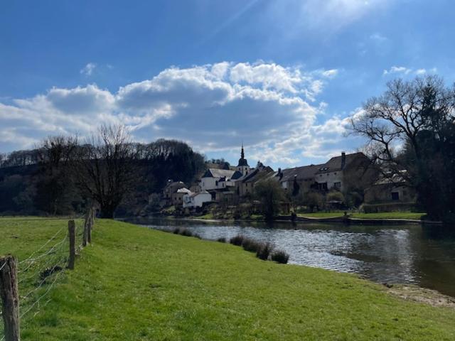 a river in a town with houses and a field at Chassepierre's Soul in Chassepierre