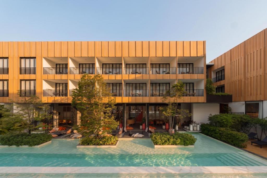 A frontal view of the pool courtyard, with balconies and loungers across the water.