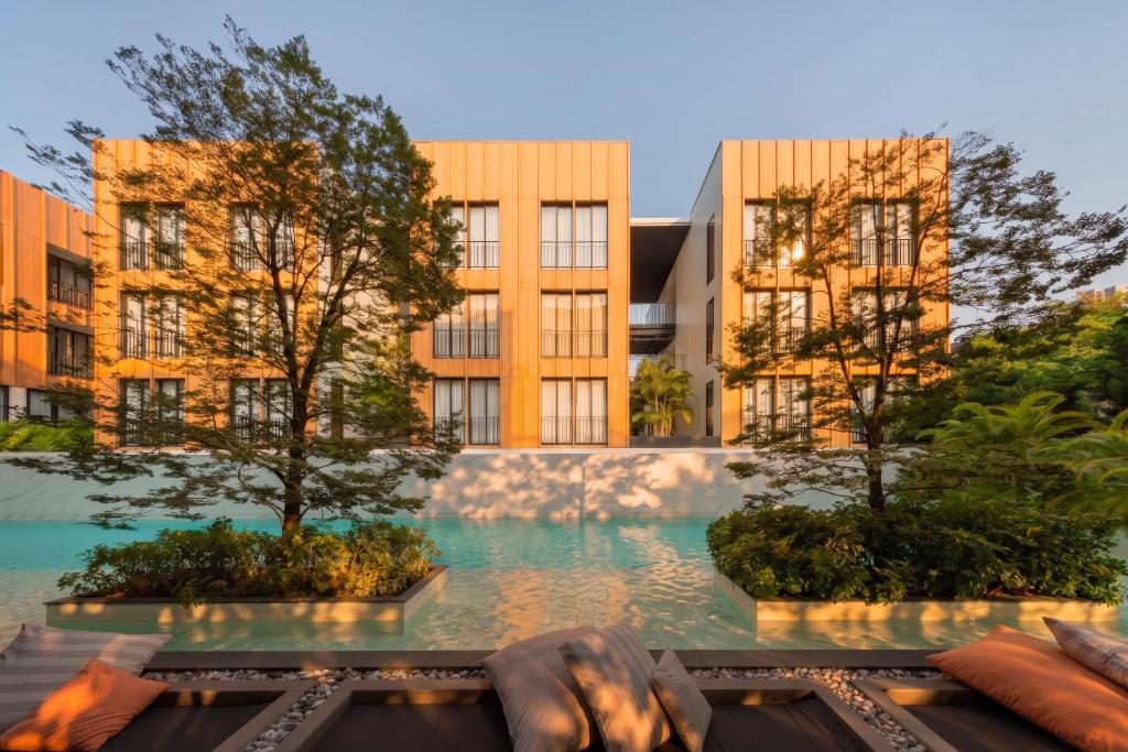A rendered pool courtyard with loungers facing warm-toned hotel buildings.