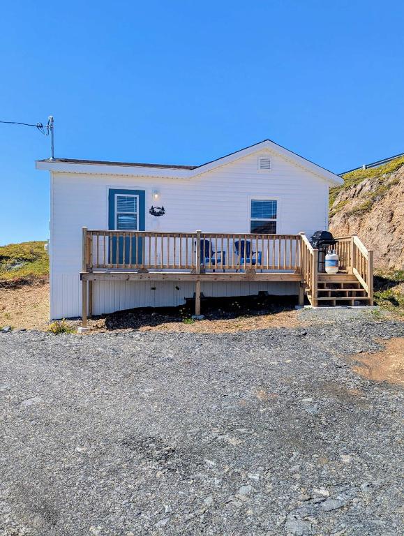 ein weißes Haus mit Veranda und Terrasse in der Unterkunft Durrell's Nook in Twillingate