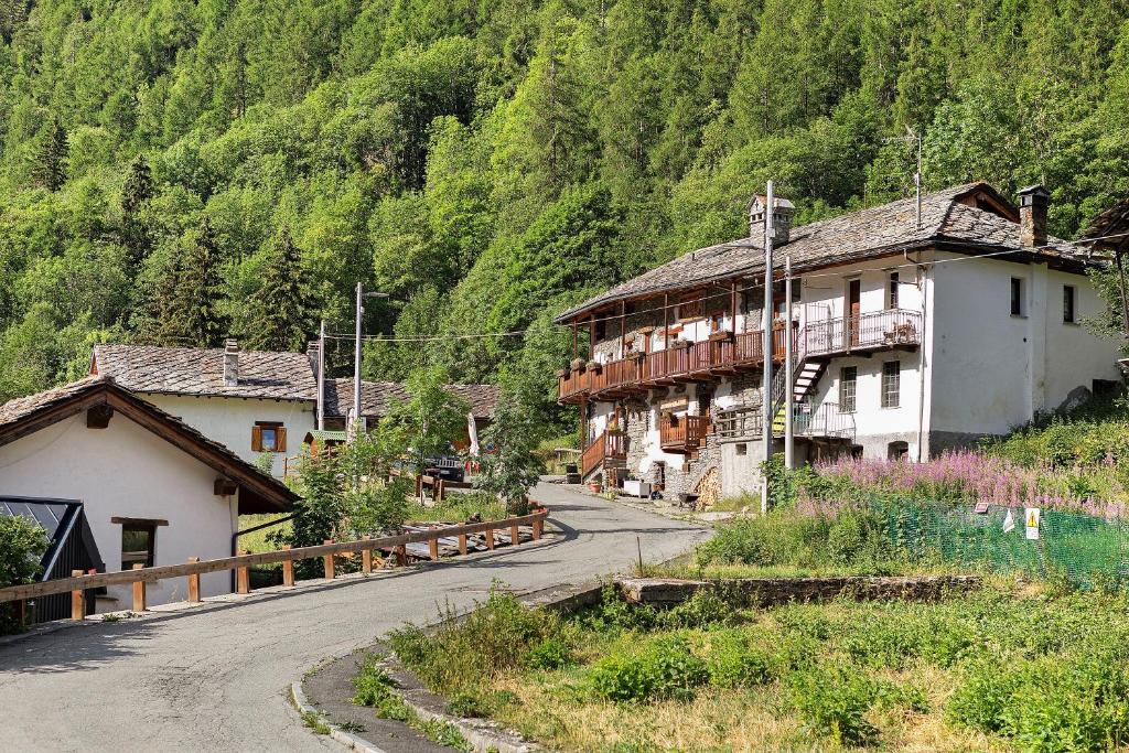 a winding road in a village with a mountain at Locanda delle Miniere in Ollomont