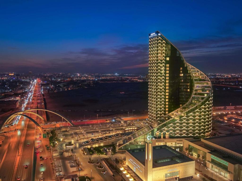 a night view of a tall building with a street at Sofitel Riyadh Hotel & Convention Centre in Riyadh