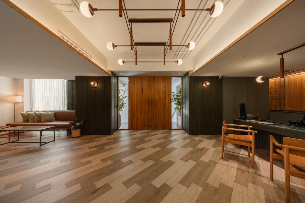 A polished lobby with lounge seating, a reception desk and a wood-lined entrance.