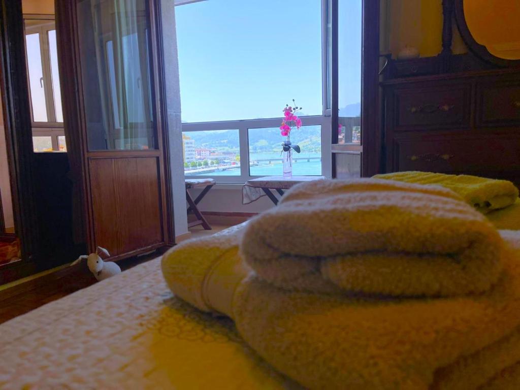 a room with two beds and a large window at El Pescador in Ribadesella