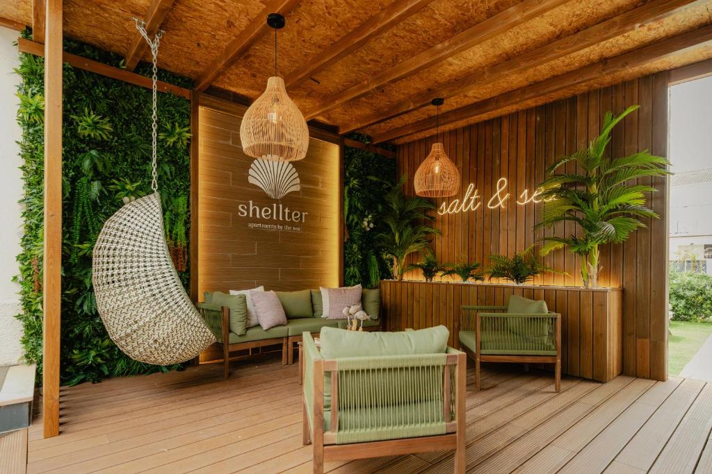 a patio with chairs and hammocks on a deck at Shellter Apartments by the sea in Vieira de Leiria