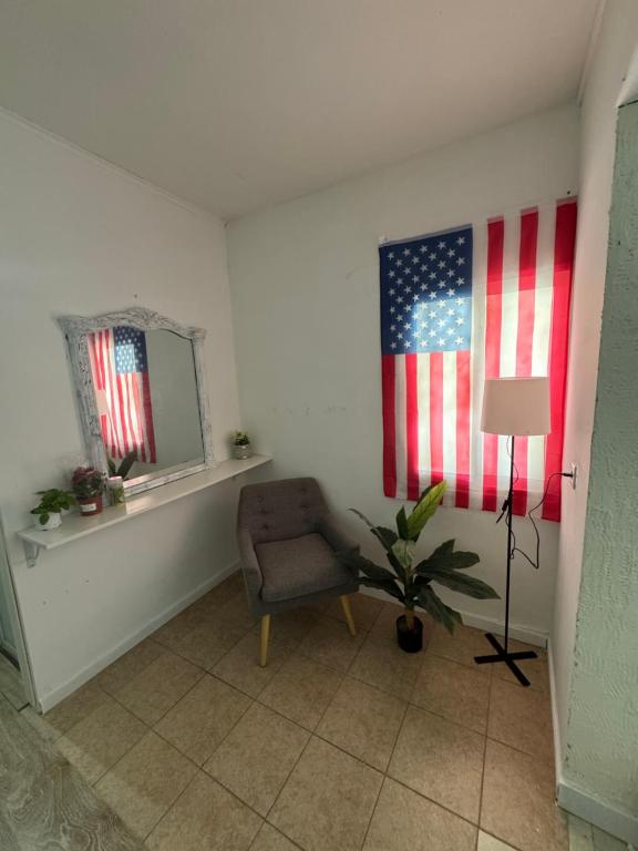a room with a chair and an american flag on the wall at Home Star 2 in Dāliyat el Karmil