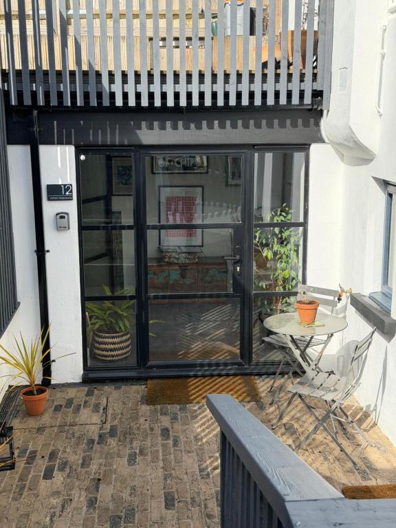 a patio with a table and chairs and a balcony at Artists Hideaway in Battle