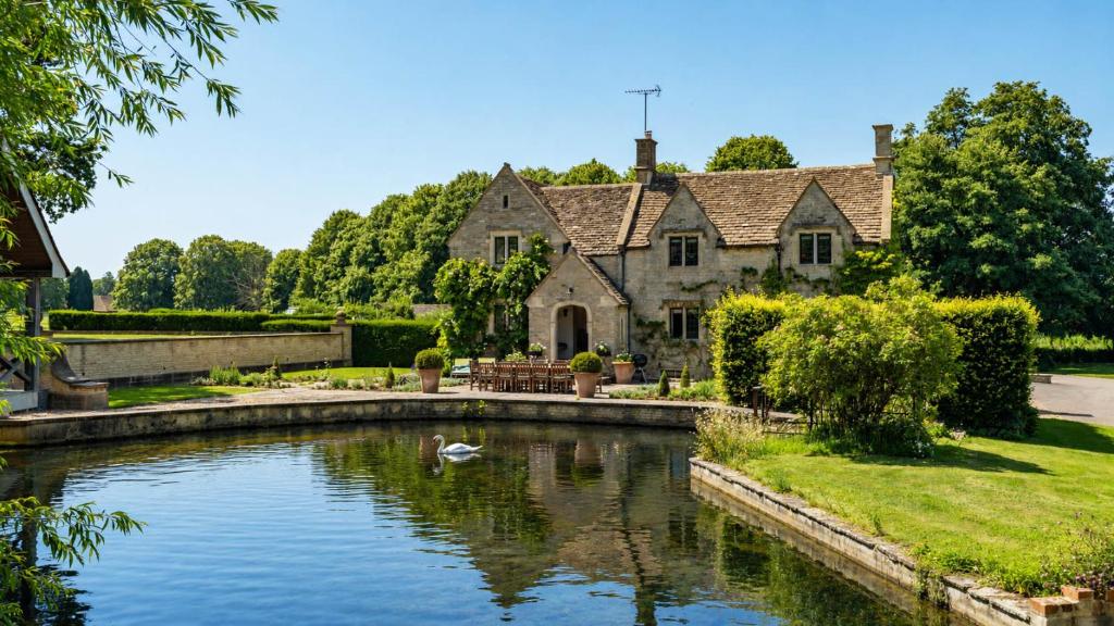 a house with a pond in front of it at Grindstone Mill in Alderley